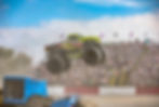 Wide angle view of a monster truck crushing cars